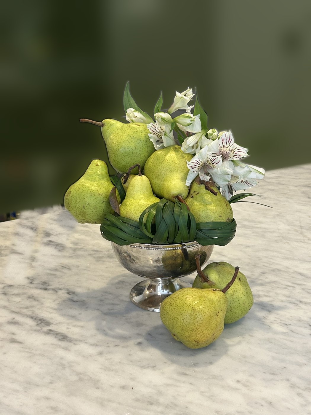 Pears stacked in a silver footed bowl with a woven grass collar and white alstroemeria (photo 2 of 2)