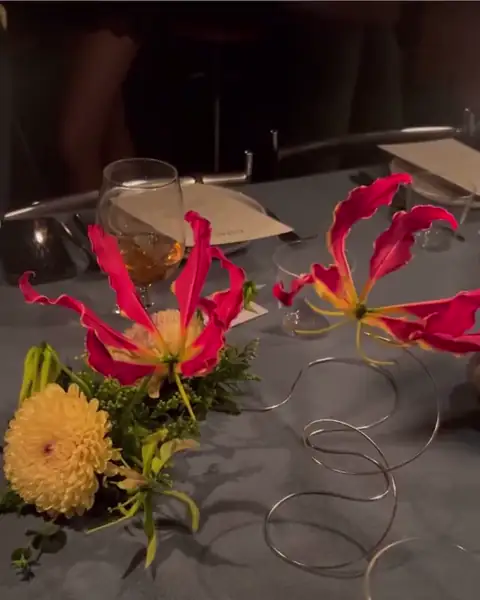 Close video of gloriosa lilies and a chrysanthemum among coils of wire (3 of 3)